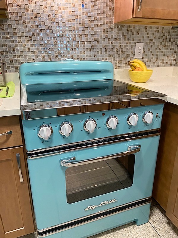 New retro stove in Turquoise with complementary backsplash.