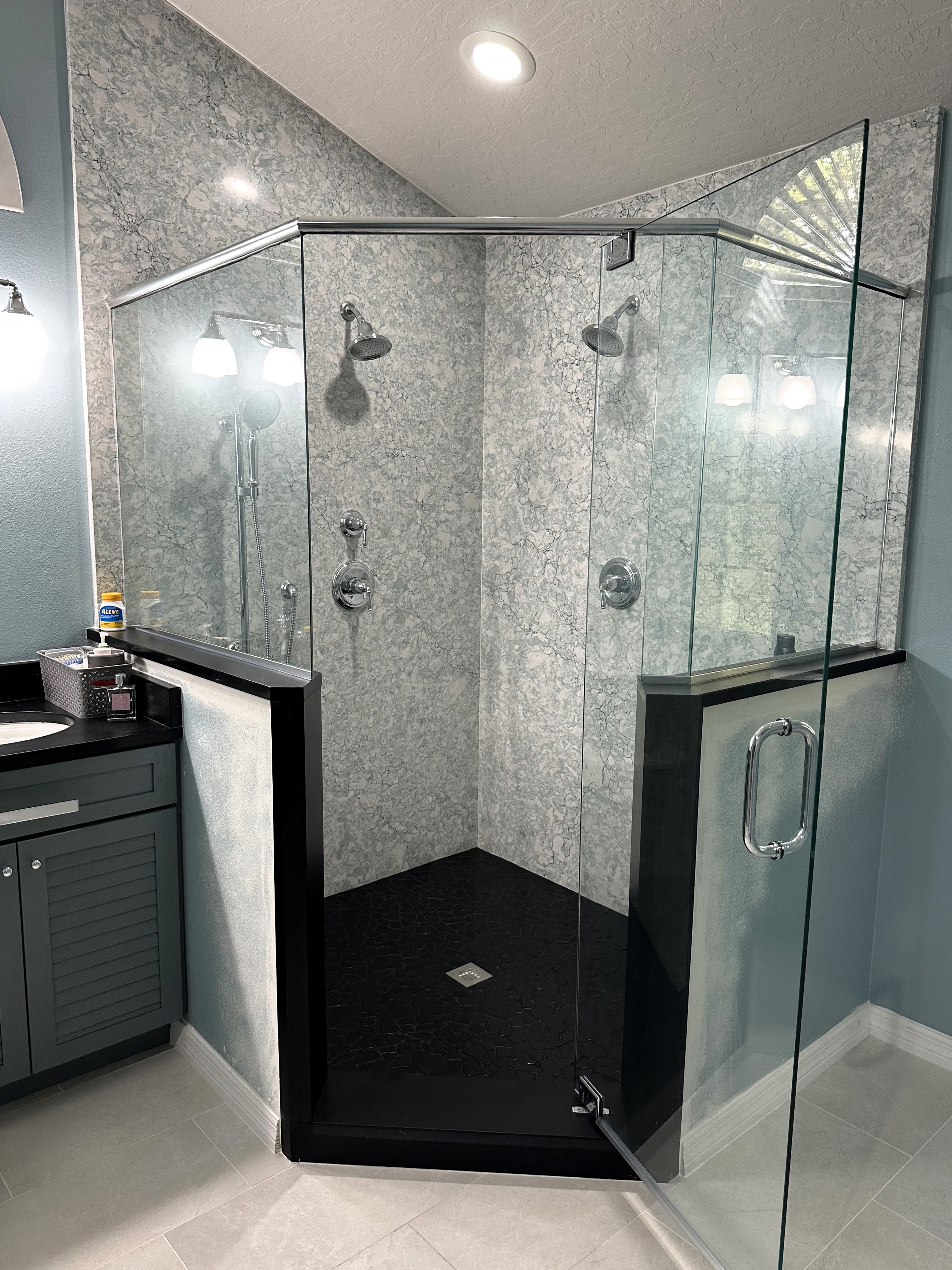 Massive shower featuring full Cambria Kendal quartz shower walls with Cambria Matte Black Pool quartz shower curb, shower caps, and heavy 3/8" clear glass panels and door.