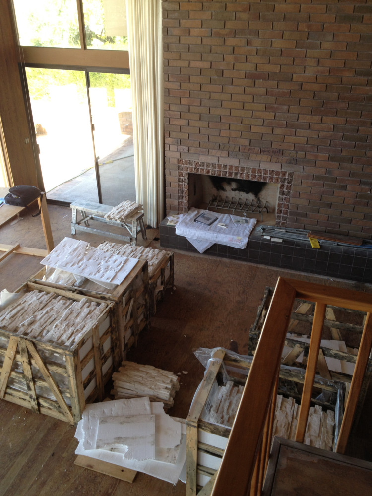 BEFORE - Bricked fireplace and wooden staircase.