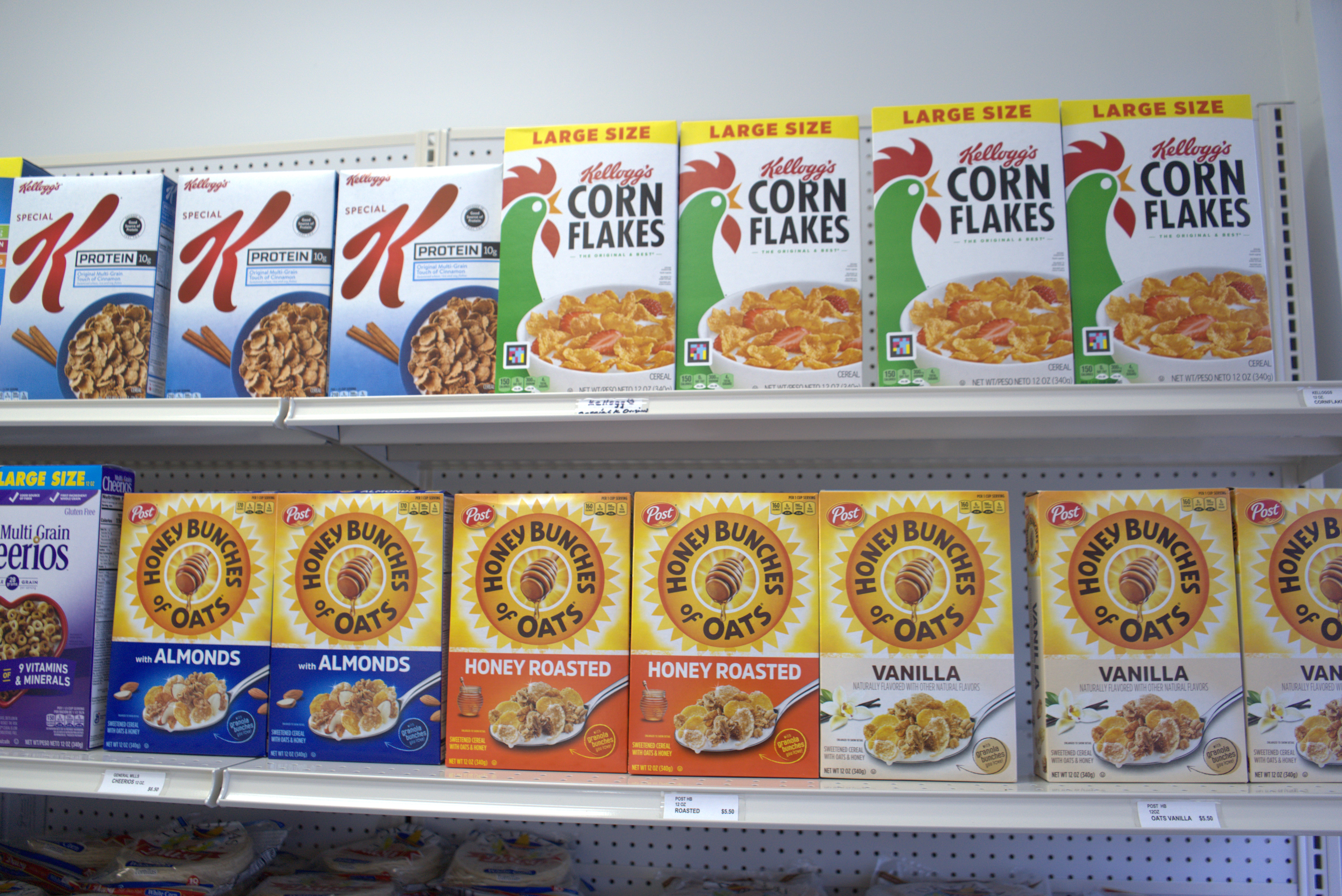 Colorful assortment of fresh fruits, vegetables, pasta, dairy, and cheese on a wooden table in a grocery setting.