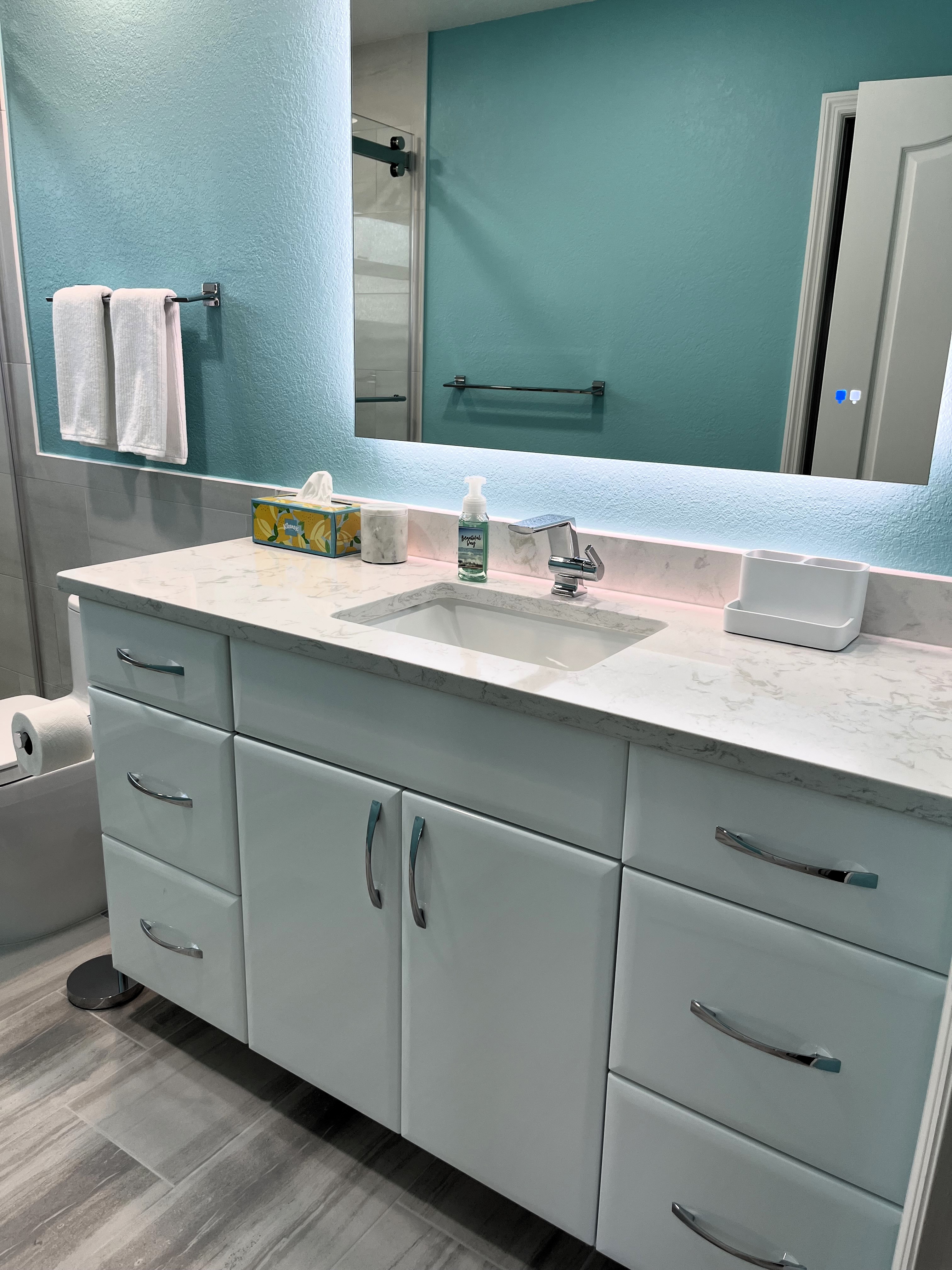 Sleek white cabinetry showcasing Cambria quartz with matching backsplash, chrome handles, and chrome faucet.