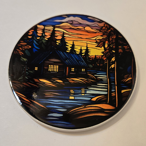 Round ceramic coaster with a stained glass cabin design