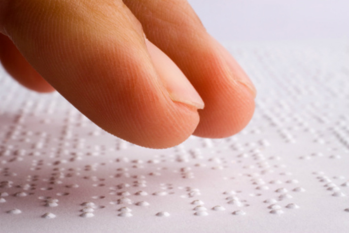Close up of finger reading braille