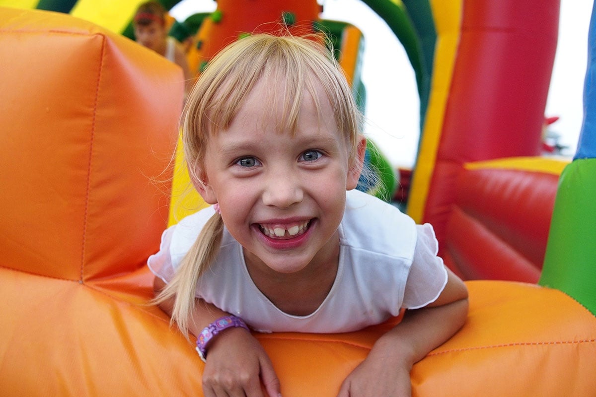 Child Playing In Bouncy Castle