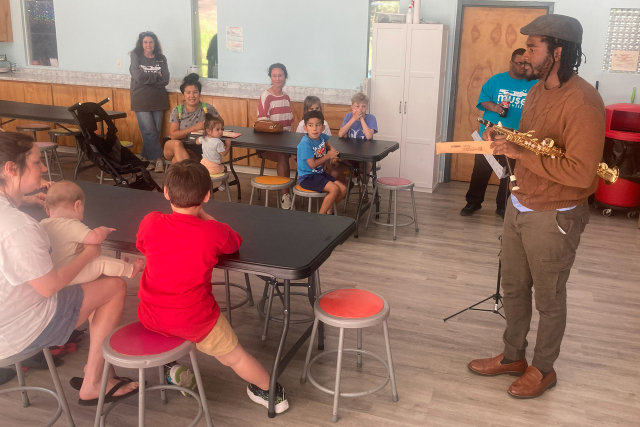 Close-up of a music production soundboard with various knobs and illuminated buttons, indicating an active audio mixing session.