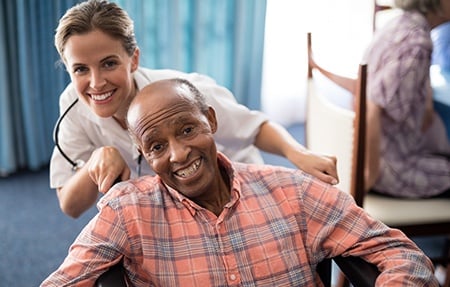 Doctor Standing with Disabled Senior