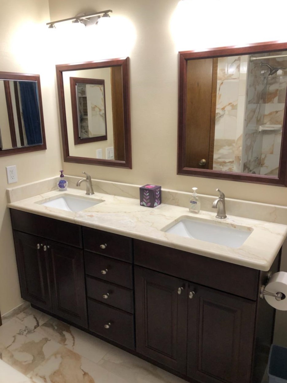 Bathroom vanity with double sinks featuring Dolomite countertop, beautifully framed matching mirrors, and medicine cabinet.