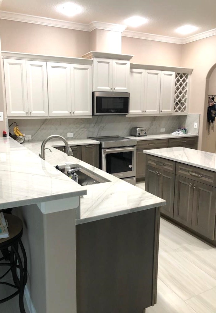 Classic kitchen featuring White Pearl Quartzite countertops and matching backsplash with painted maple Dover upper cabinetry and maple Seal-stained lower cabinetry and Island. 