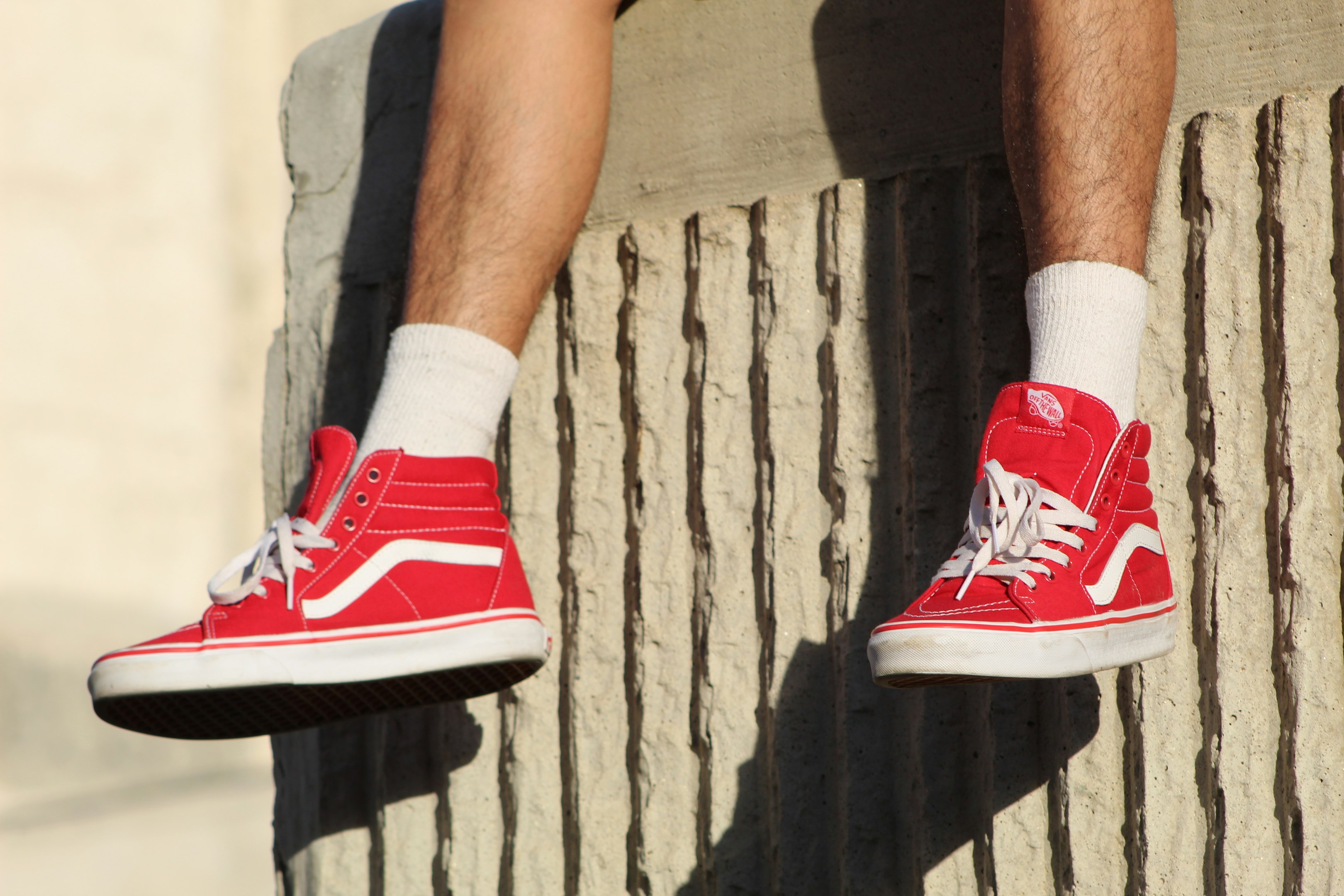 persona usando zapatillas Vans de caña alta rojas