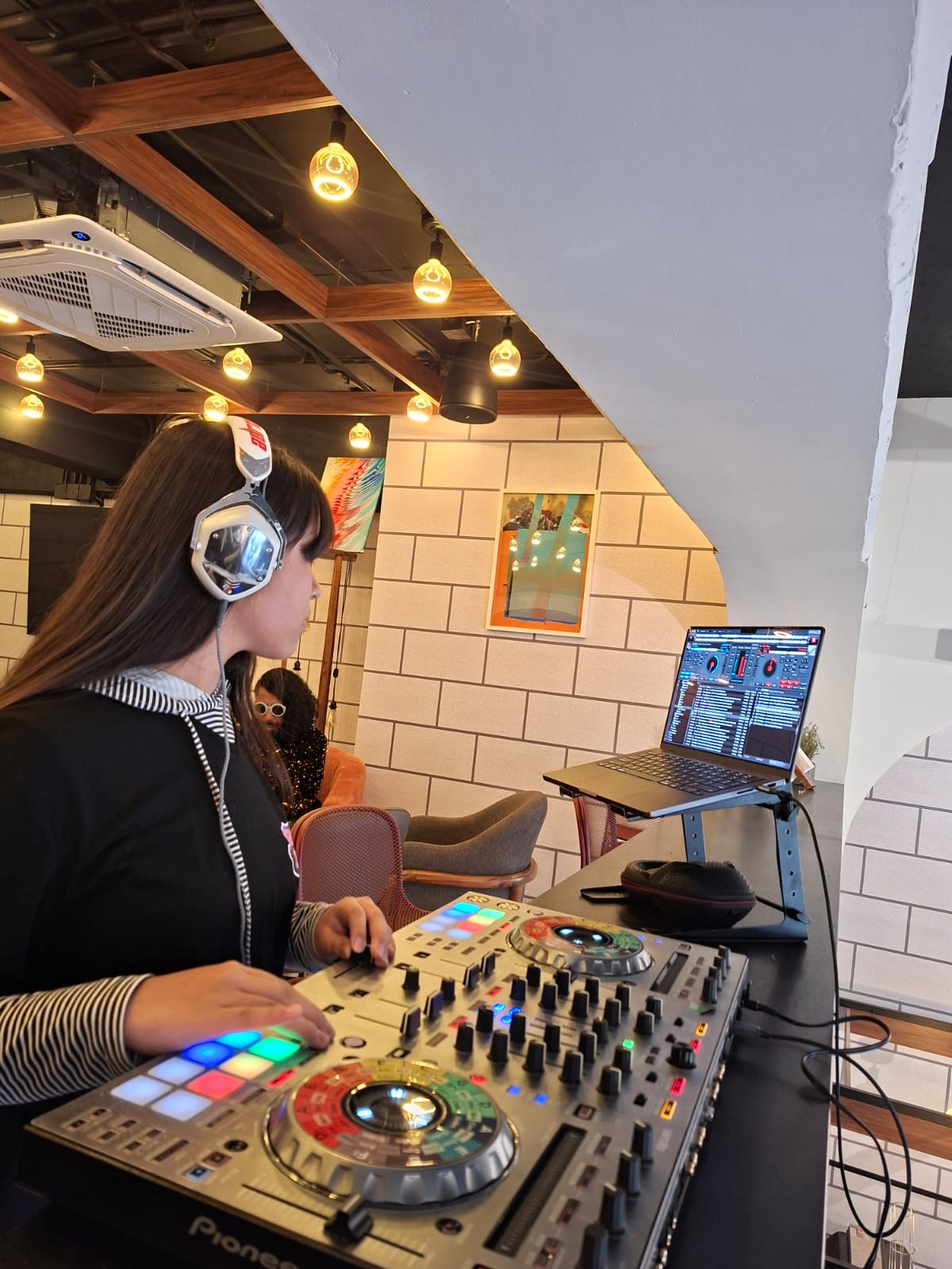 Mujer joven con blusa amarilla en un espacio moderno y luminoso con plantas y grandes ventanales. Mujer joven con blusa amarilla en un espacio moderno y luminoso con plantas y grandes ventanales.