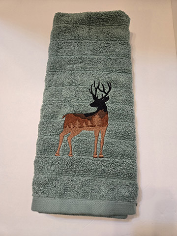 Green hand towel featuring a deer silhouette design