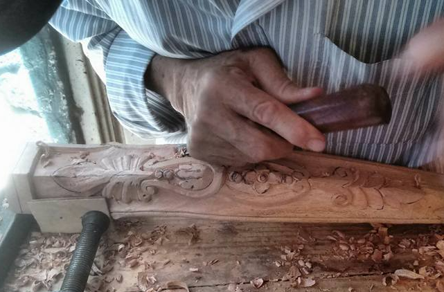 Sala de estar minimalista con mueble de madera, plantas decorativas, y cuadro en blanco.