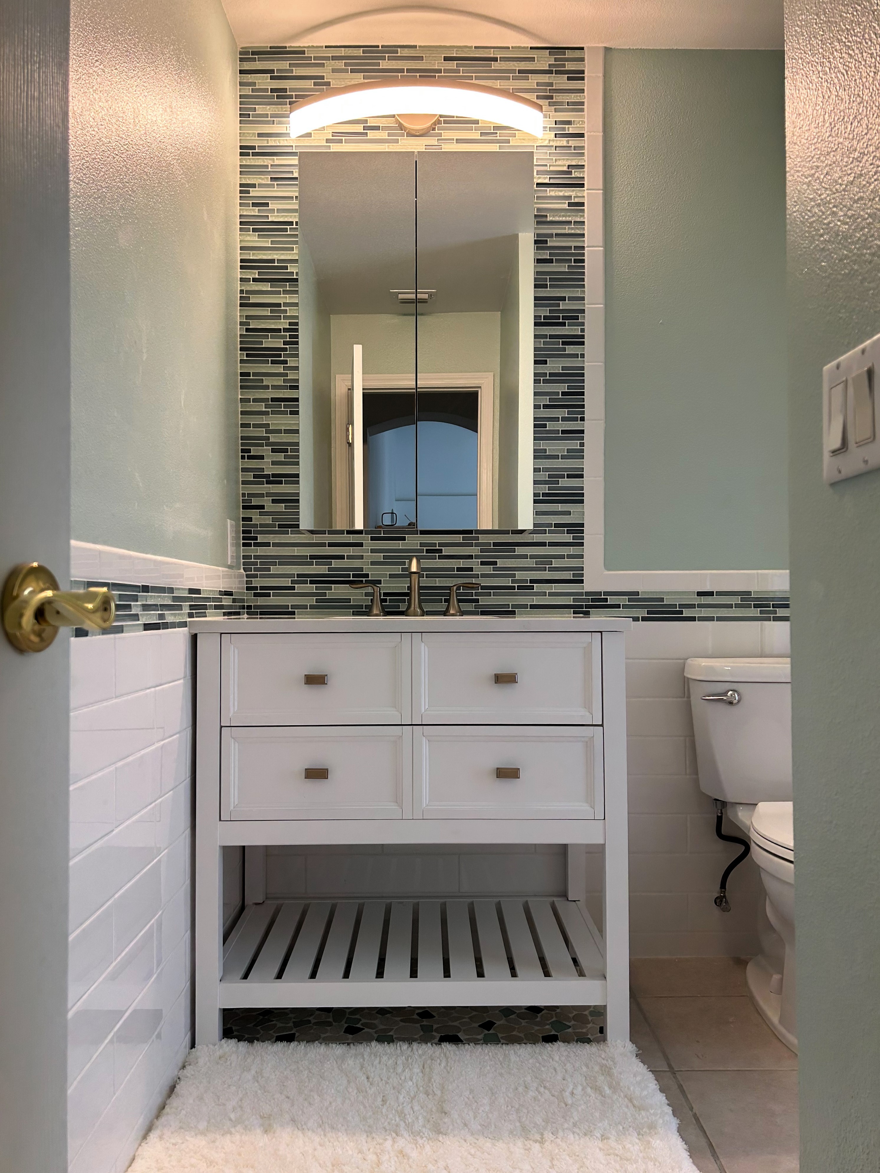 Flawless pool bath featuring linear 6x16 white glossy subway tile with matching 6x8 bullnose, and Rain Blue glass mosaics.