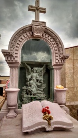 Tumba, nicho, libro, macetas y figuras