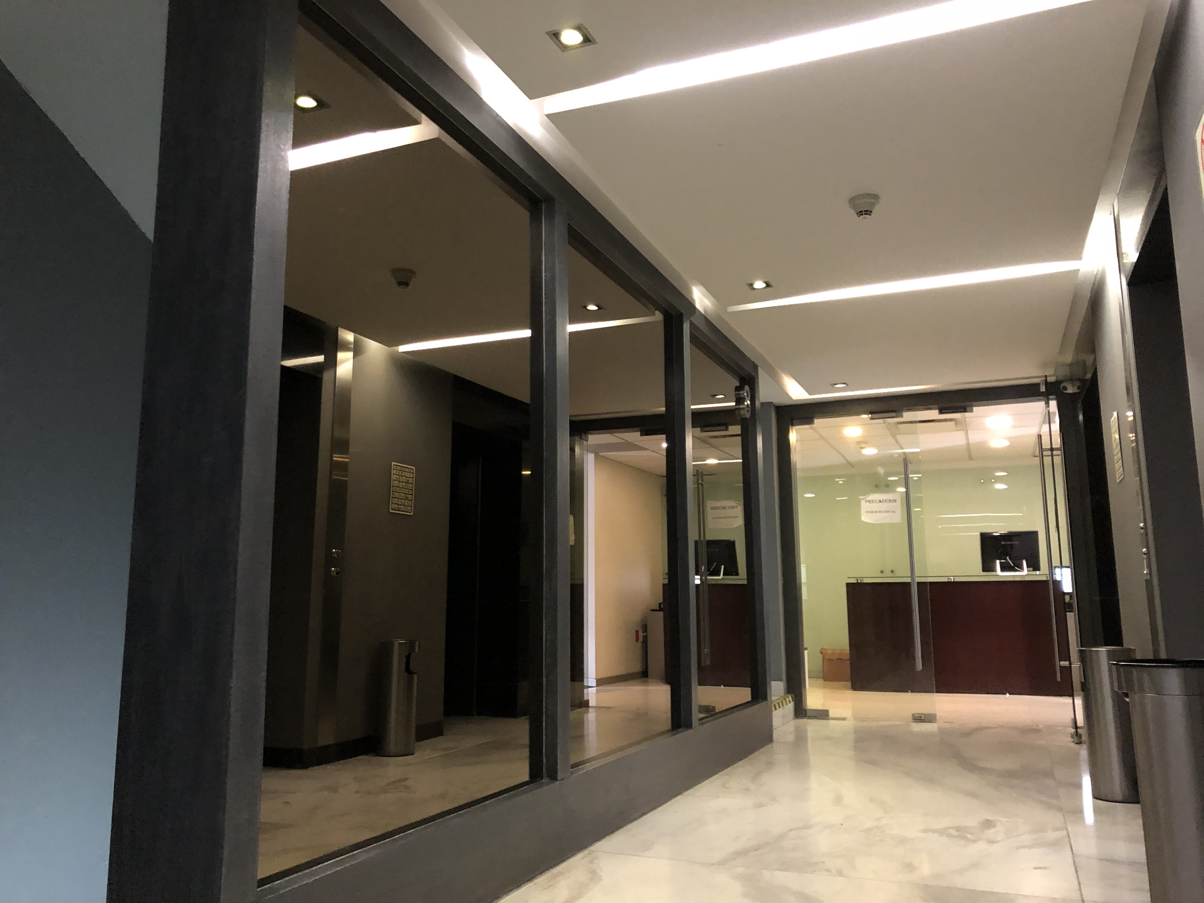 Espejos filtrasol en vestíbulo de acceso a elevadores, Corporativo Palmas, CDMX.