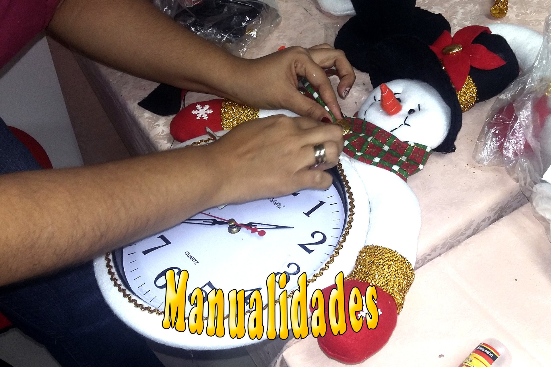 Persona decorando un reloj manualidad con forma de muñeco de nieve.
