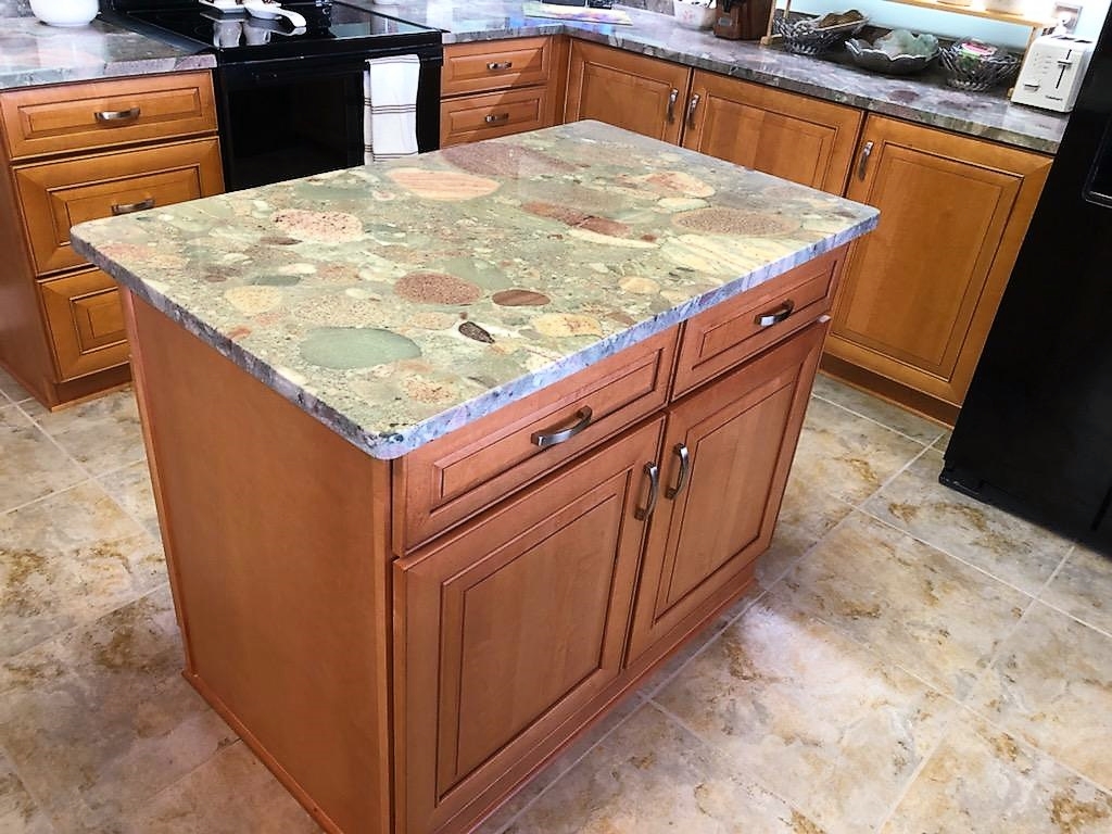 Large Island featuring tranquil Jurassic Green Granite countertops.