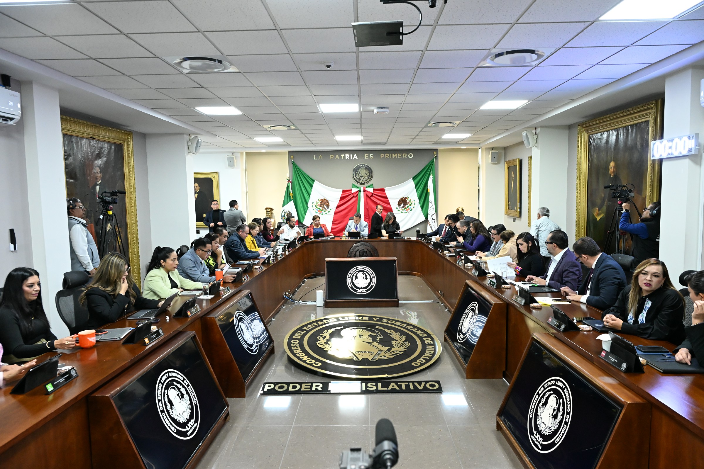 Interior moderno de oficinas con bandera de Estados Unidos, techo de cristal, pantallas digitales, zona lounge y estantería multimedia Interior moderno de oficinas con bandera de Estados Unidos, techo de cristal, pantallas digitales, zona lounge y estantería multimedia