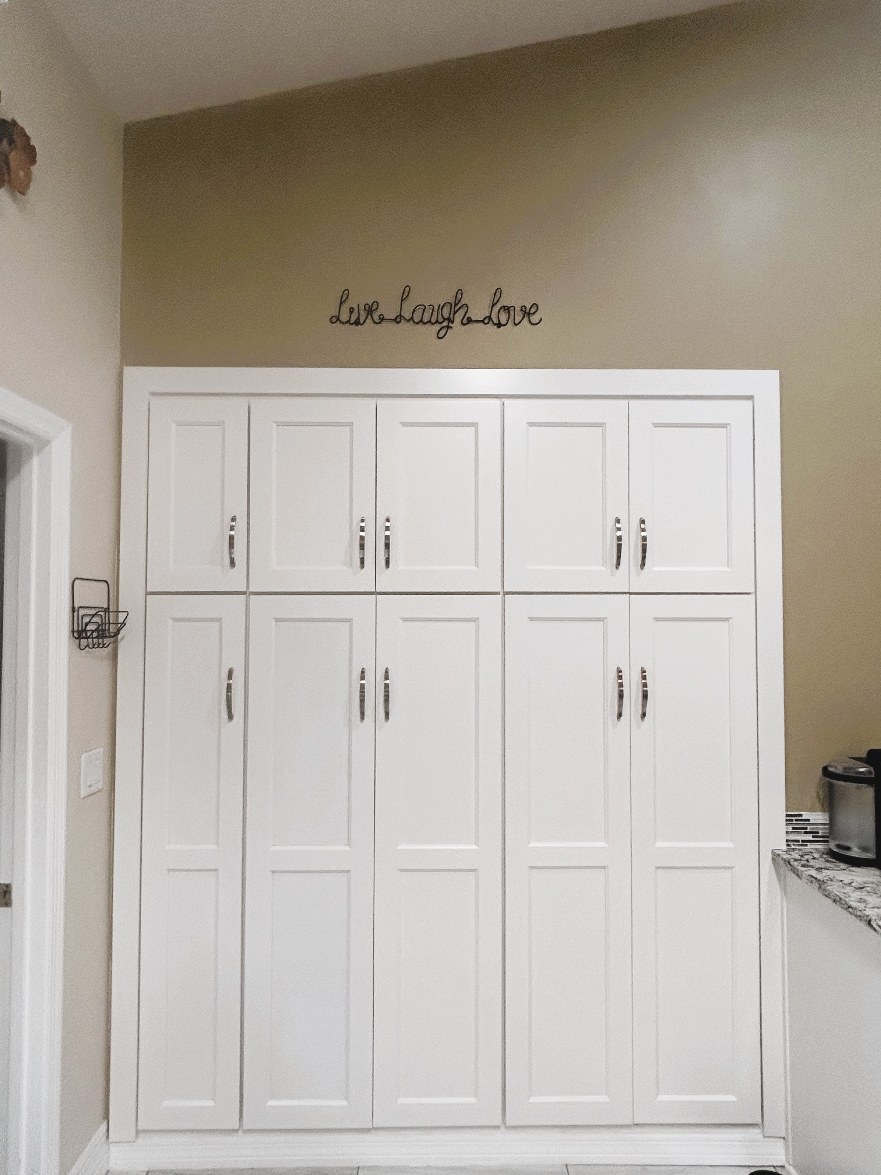 Large pantries with pullout shelving and broom closet on the end make for easy accessibility and functionality in this kitchen.