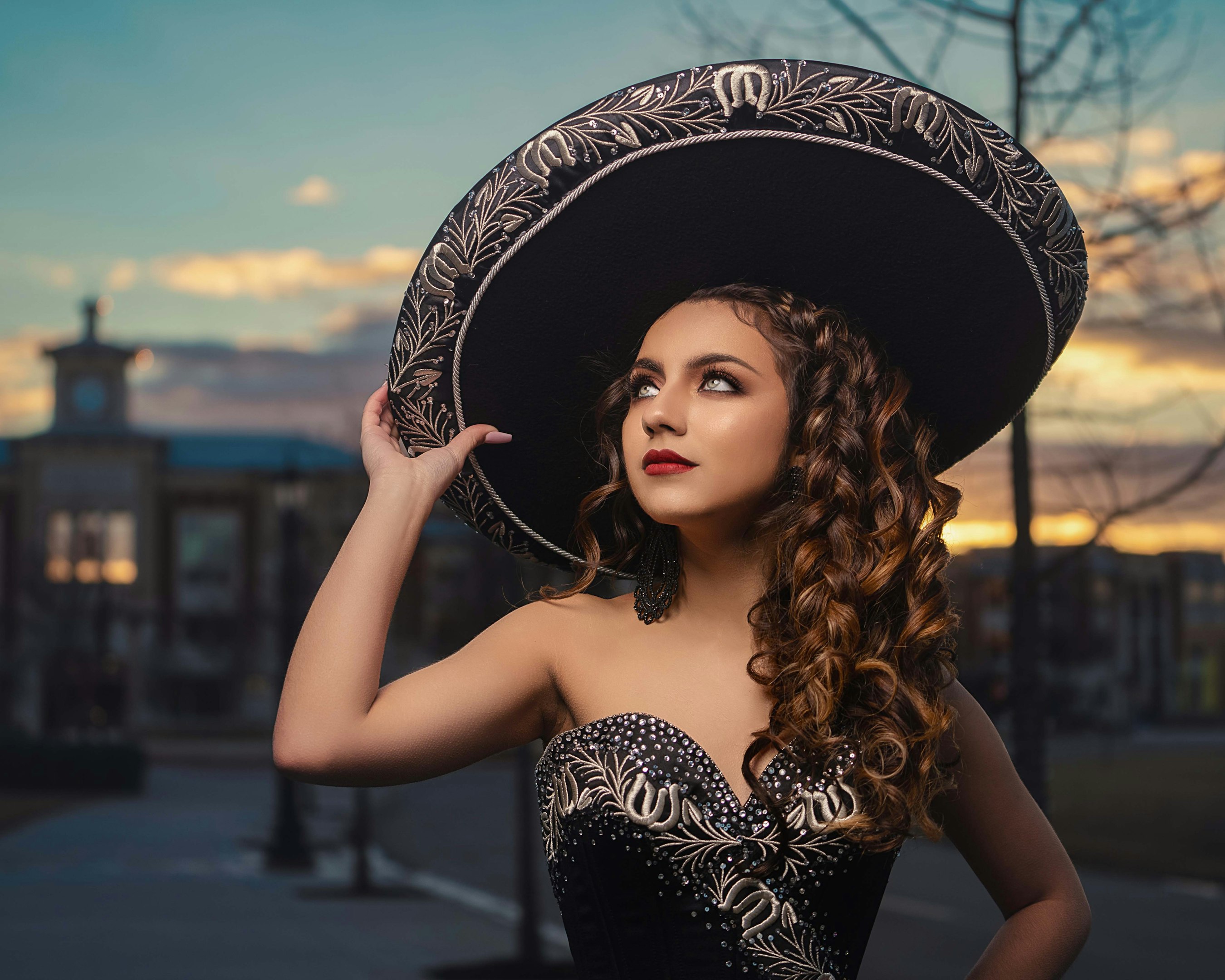 mujer con sombrero floral en blanco y negro y vestido tubo negro