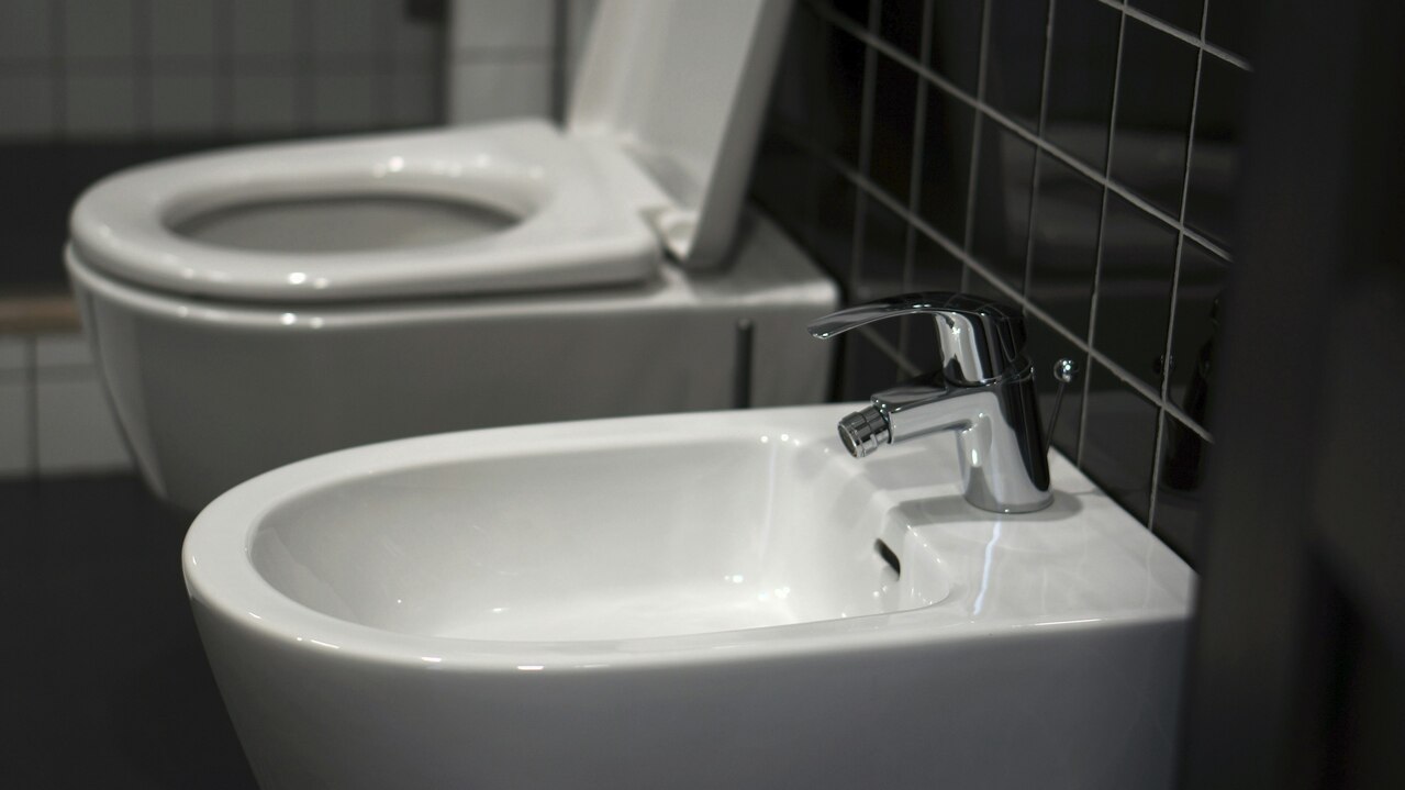 Un inodoro blanco junto a un lavabo blanco