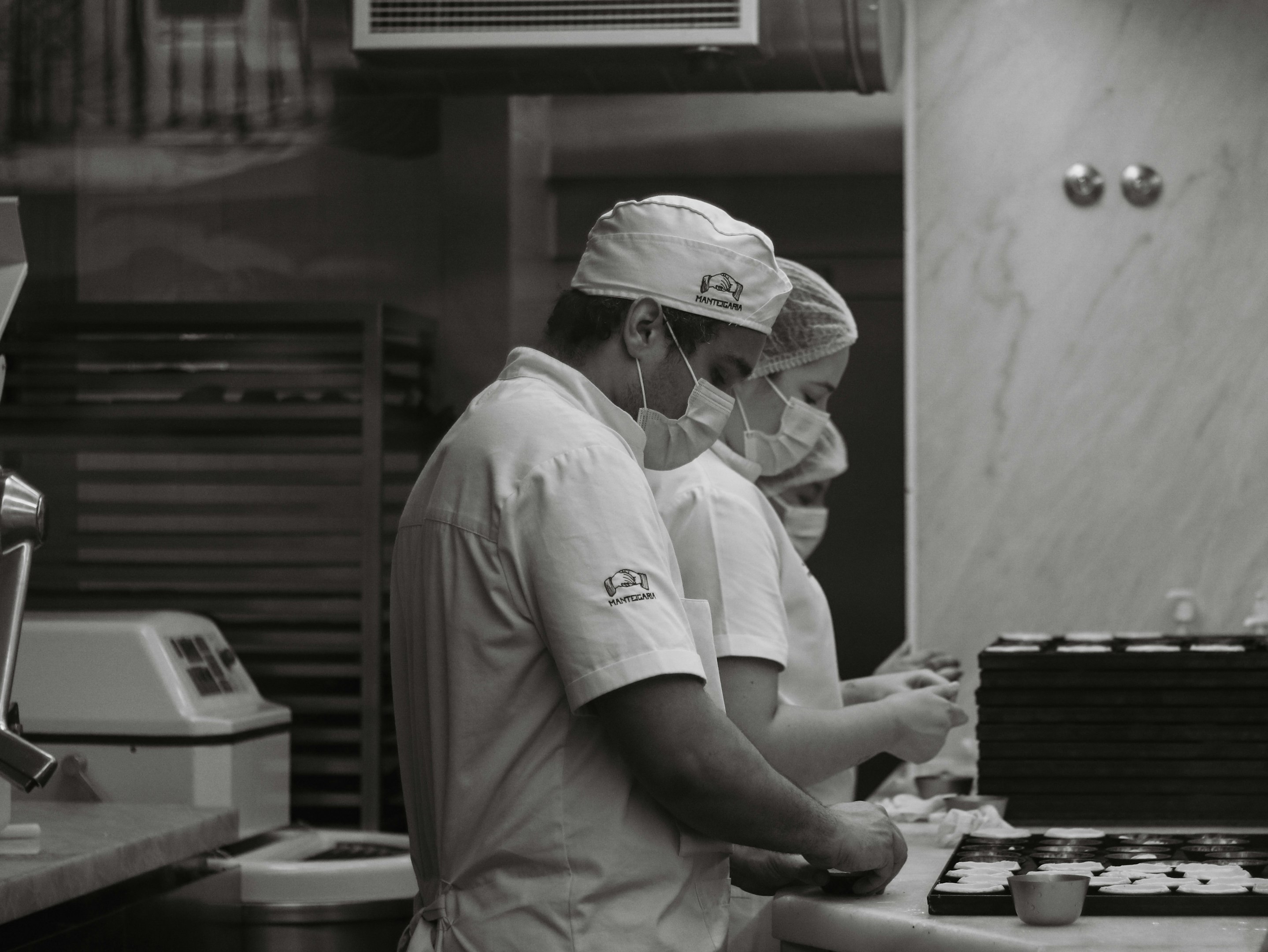 a couple of people in a kitchen preparing food