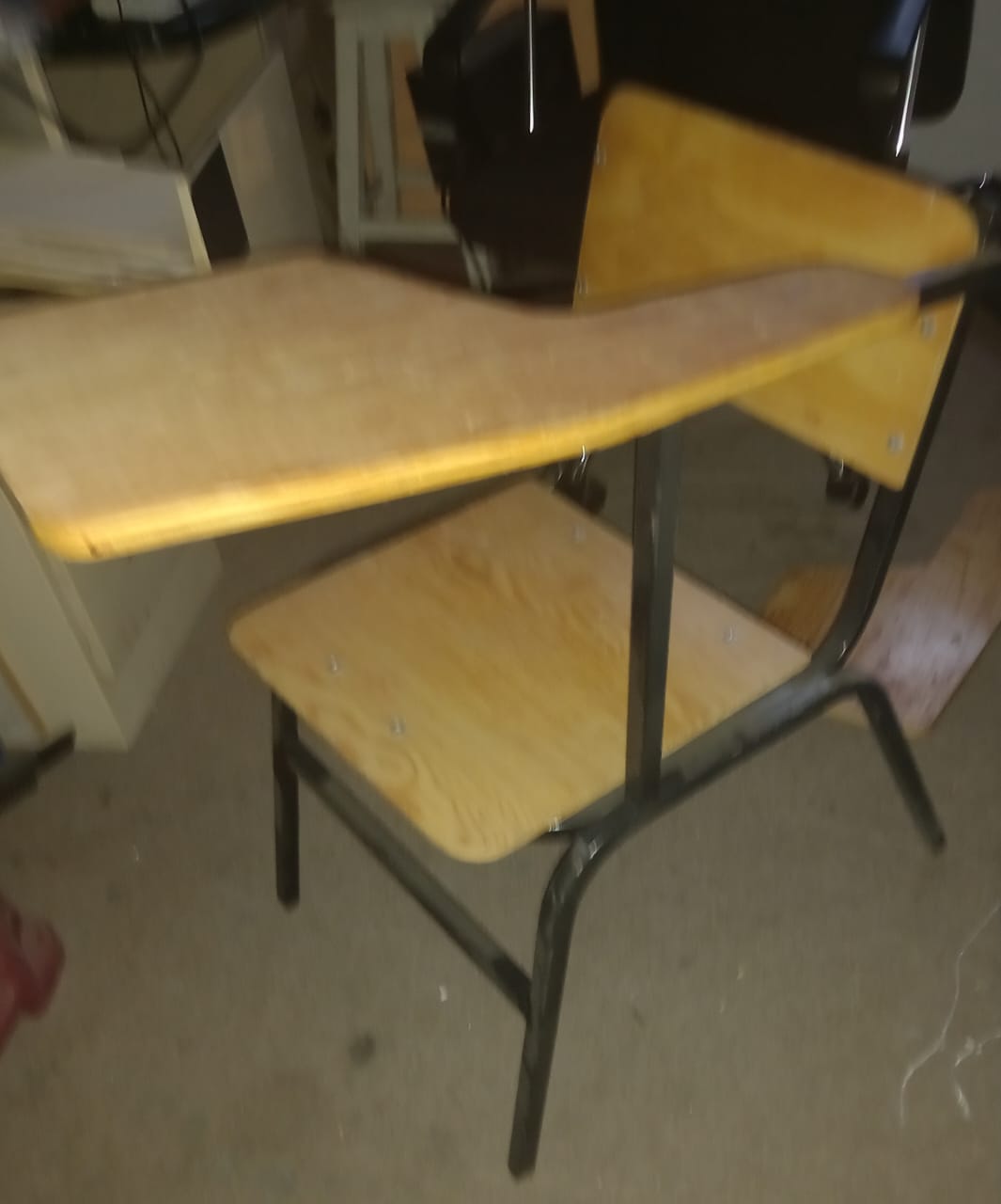 Portátil sobre escritorio con pantalla mostrando lista de espera, rodeado de libros, cuadernos y tazas con lápices de colores.