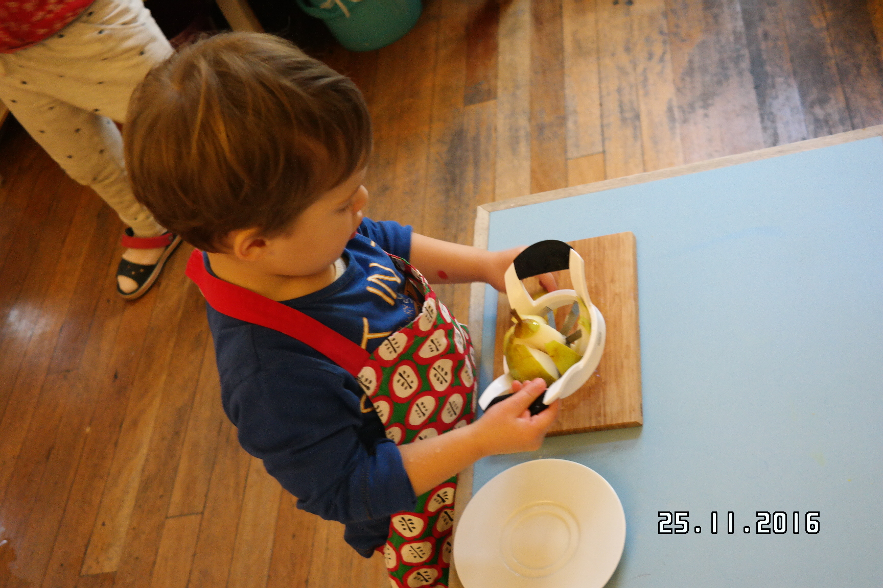 Child preparing a pear for snack. 