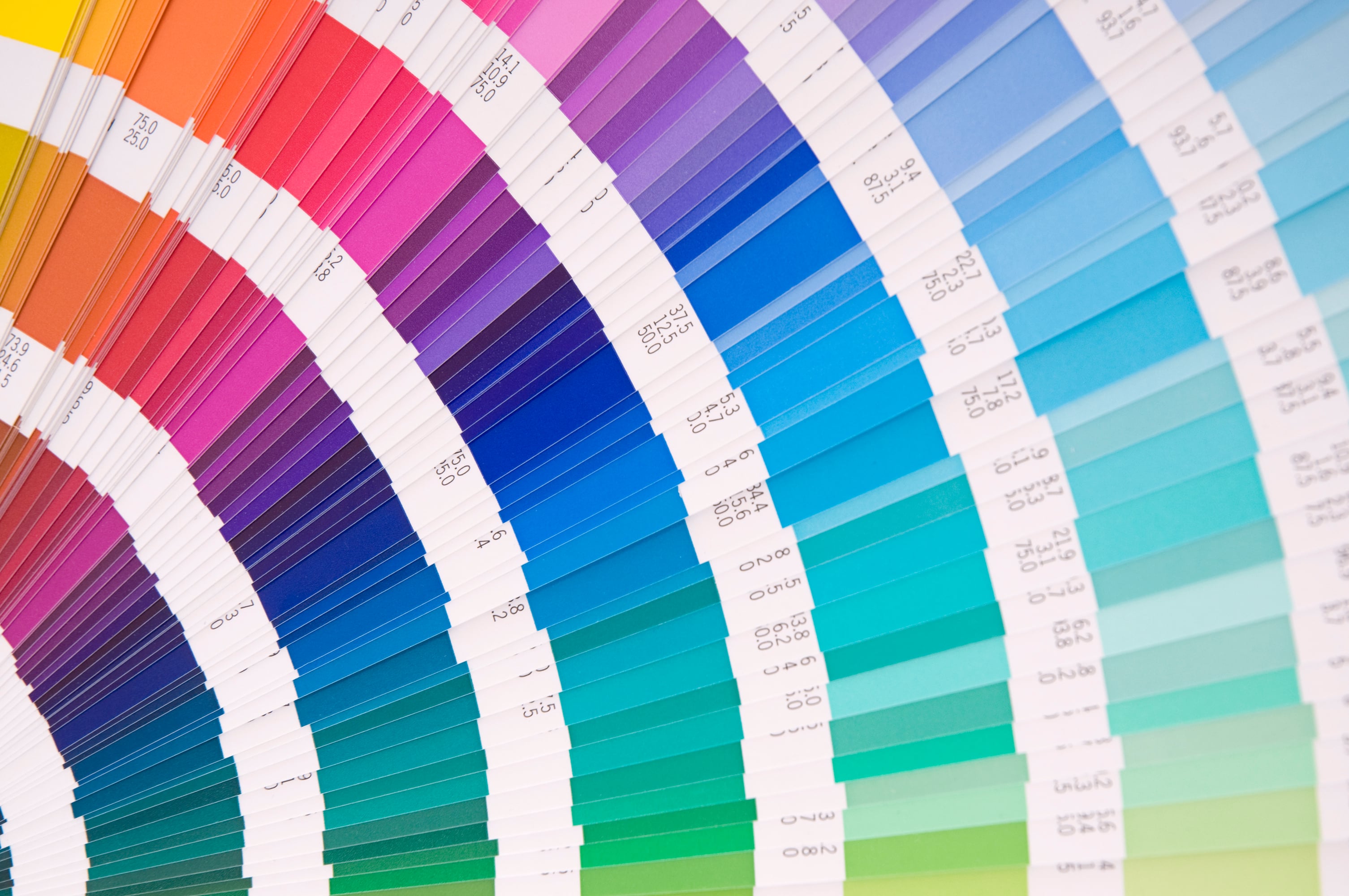 Color swatch fan deck with vibrant paint samples in pink, purple, blue, teal, and green shades