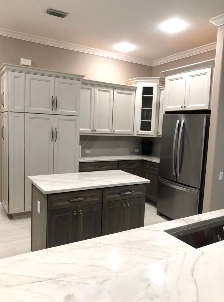 Spacious kitchen featuring large pantries, glass inserted corner cabinet for decorative pieces, and large Island with electrical outlet for easy accessibility.
