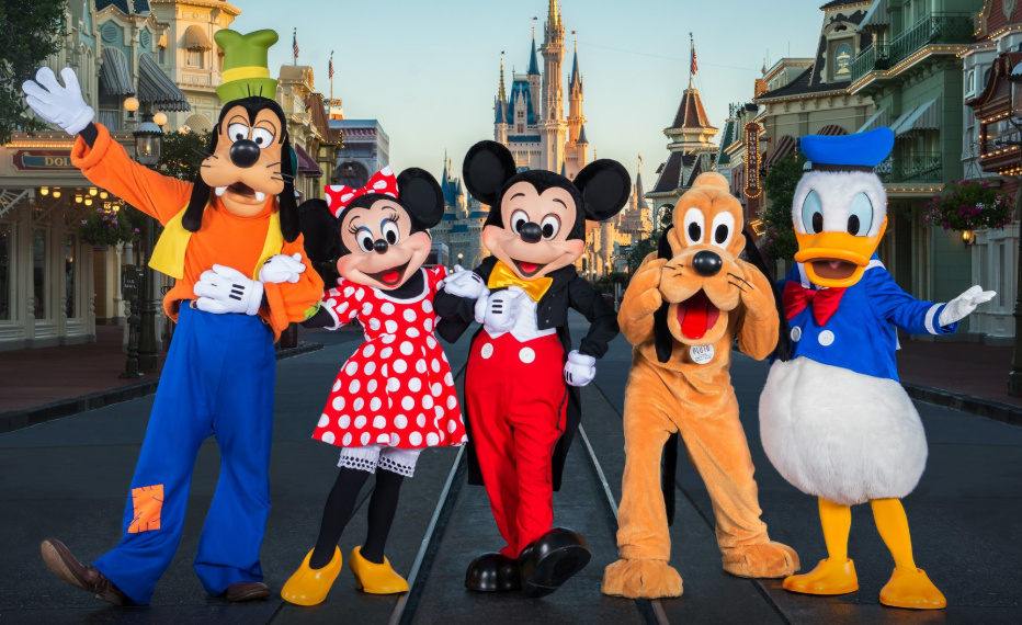 Personajes de Disney en un parque temático con un castillo de fondo.