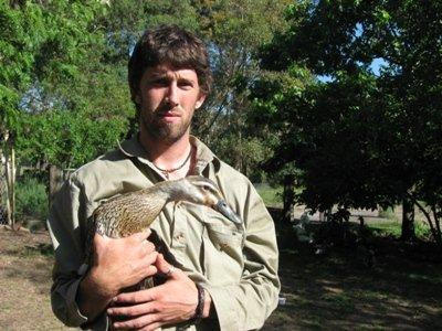 Brendan with a rescued duck that has fishing line down its throat attached to a hook on its beak.