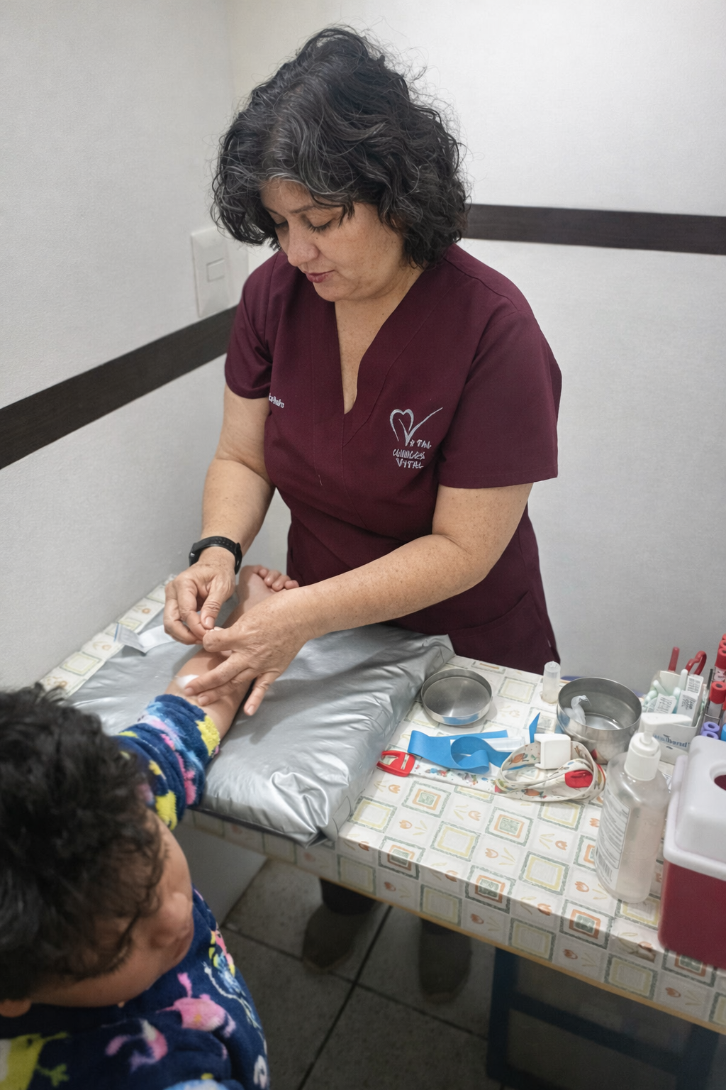 Médica en uniforme burdeos atendiendo a un paciente en una clínica.