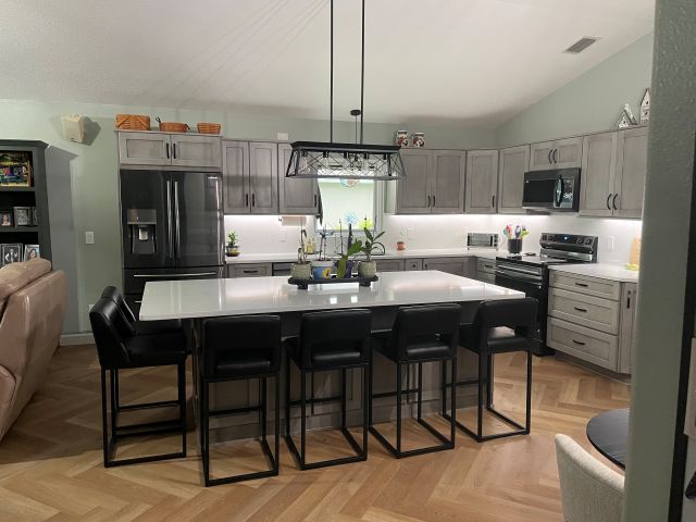 The large central island offers the perfect space for meal preparation, casual dining, and gathering with family and friends.