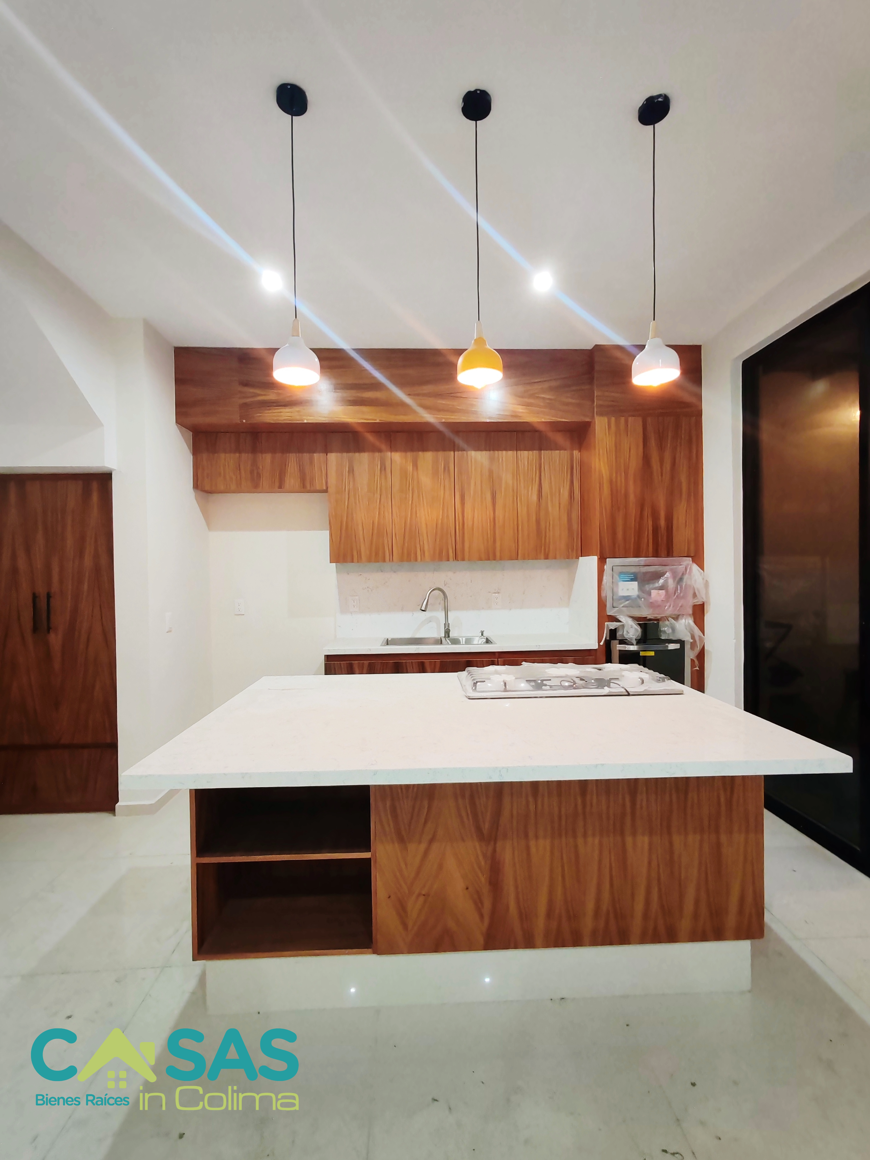 Edificios de apartamentos altos con fachada de colores amarillo, naranja y rojo bajo un cielo azul claro.