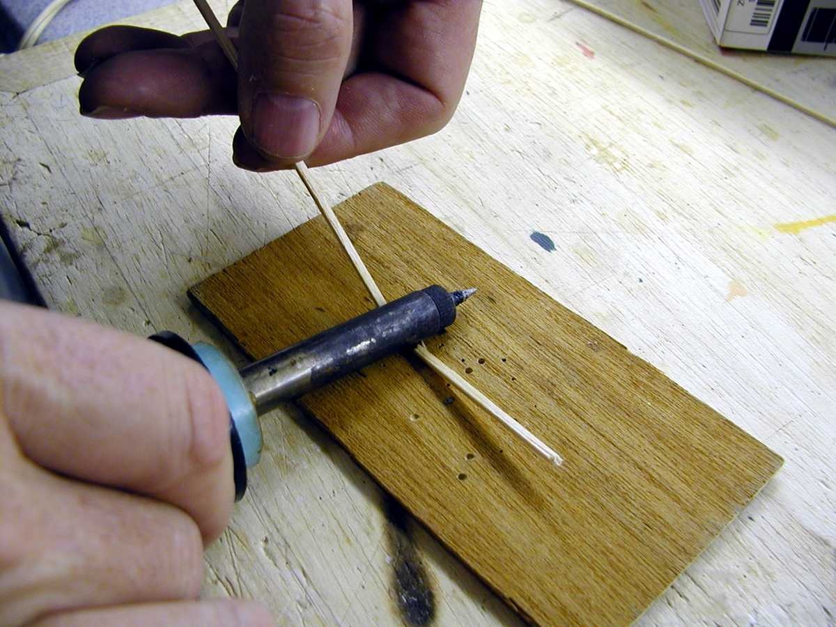 Pull up on the free side of the wood strip. Do this gently and a little at a time. The heat of the soldering iron will turn the water to steam. This will make the wood very pliable. Pull up and bend in small steps. Re-wet the wood often to make sure there is plenty of water to create steam.
