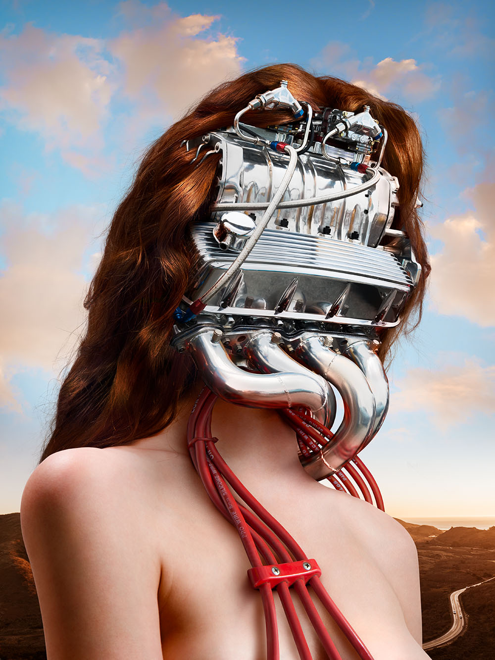 Frida Kahlo inspired composite photo of woman with chrome automobile engine for her head, with red ignition wires extending over her bare chest.  