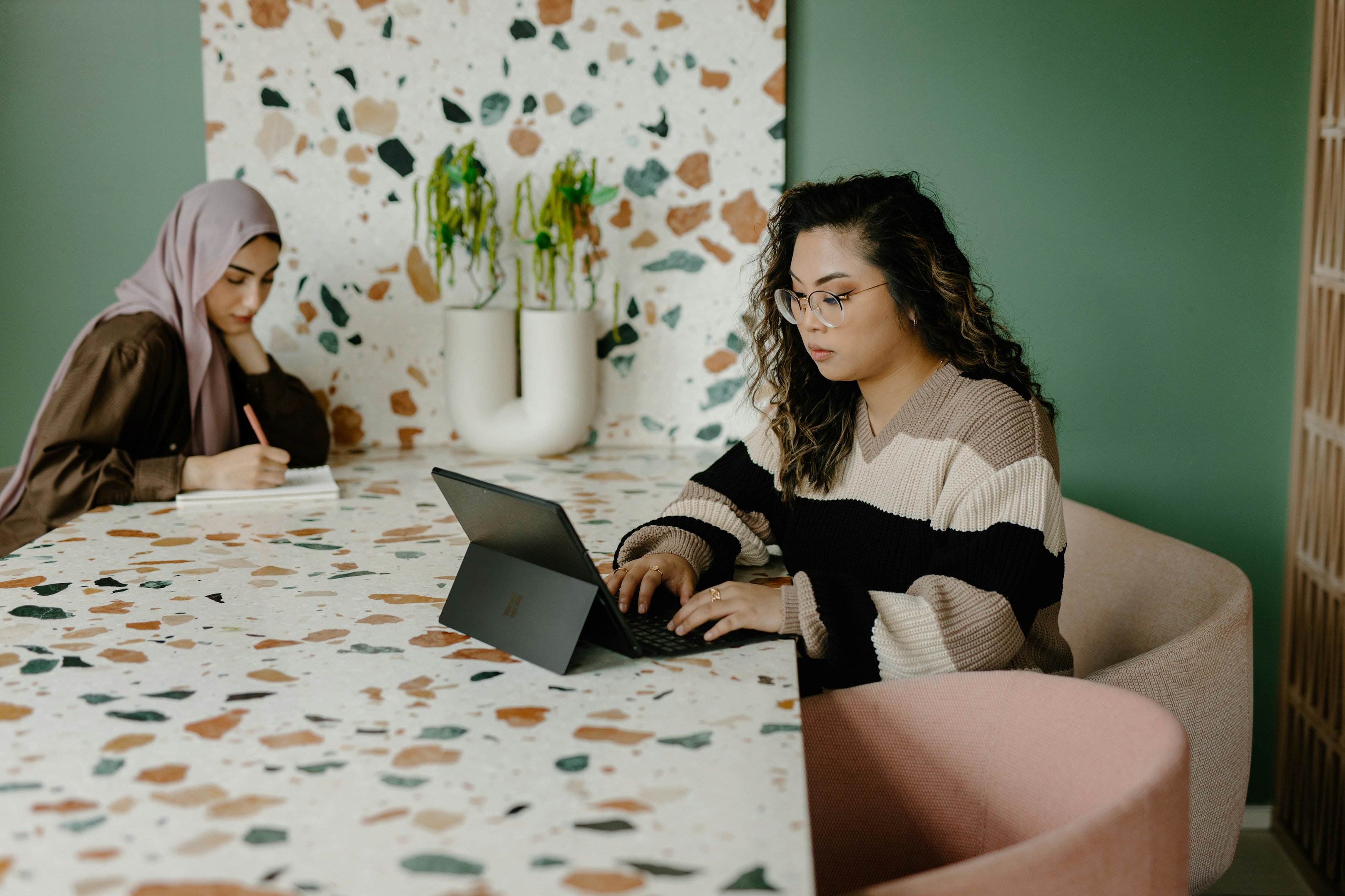 Dos mujeres sentadas a una mesa trabajando