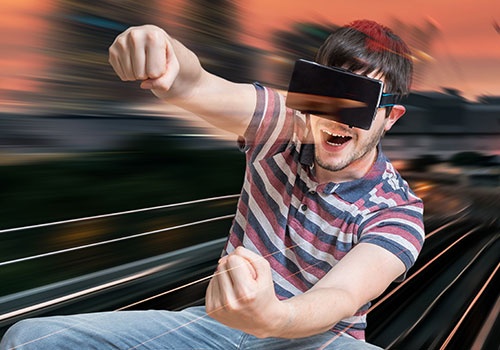 Happy young Man is Playing Racing Videogame in 3D Virtual Reality 