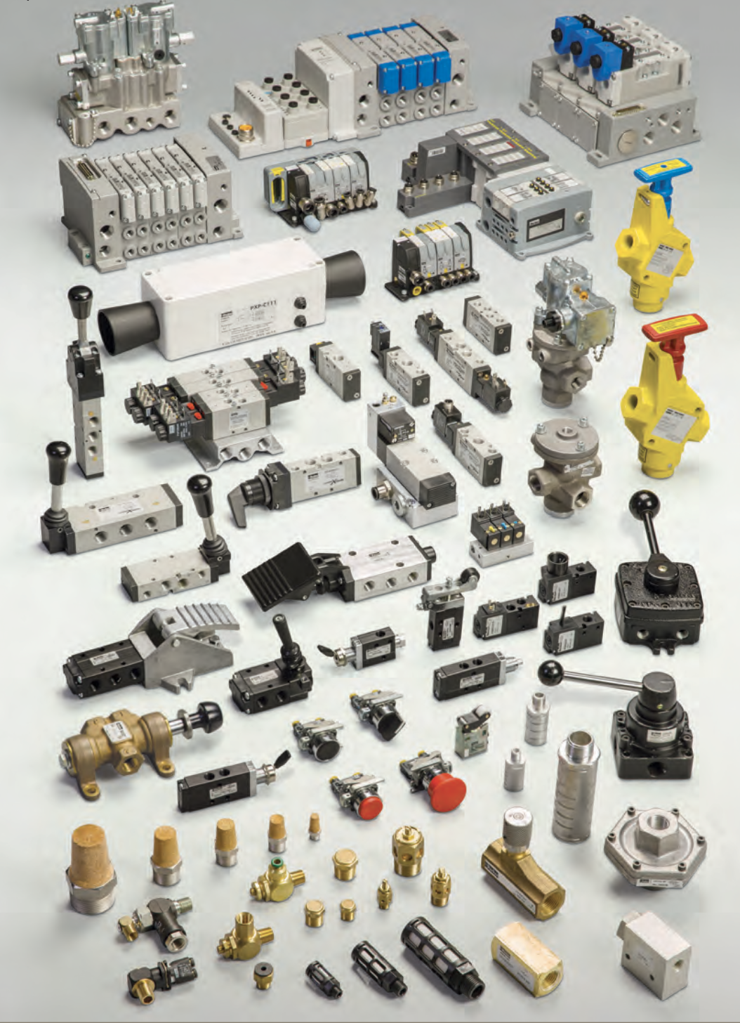 Assorted industrial pneumatic and hydraulic valve components displayed on a light surface.