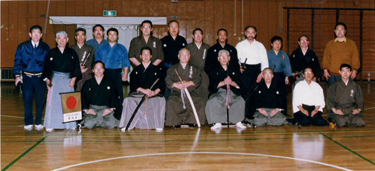  	January 1995. Front row center: Nakamura Taizaburo sensei flanked by Sato Shimeo (Hanshi 9th dan) and Suzuki Kunio (Kyoshi, 8th dan) on the left. Back row, 4th from the right: Ron Zediker (Renshi, 6th dan).