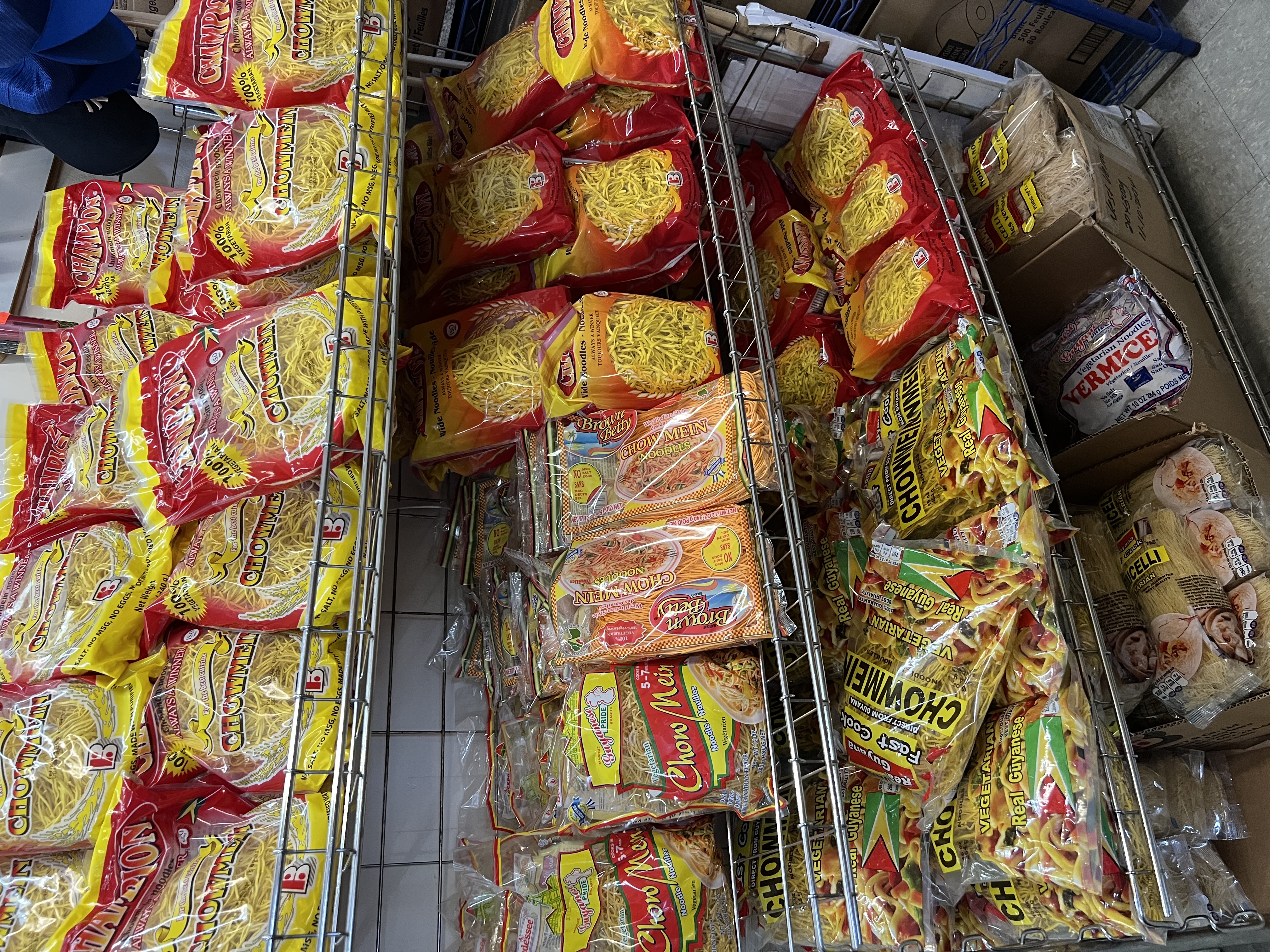 Delicious plate of saucy spaghetti garnished with fresh herbs and diced tomatoes, with jars of sauces and ingredients in the background.