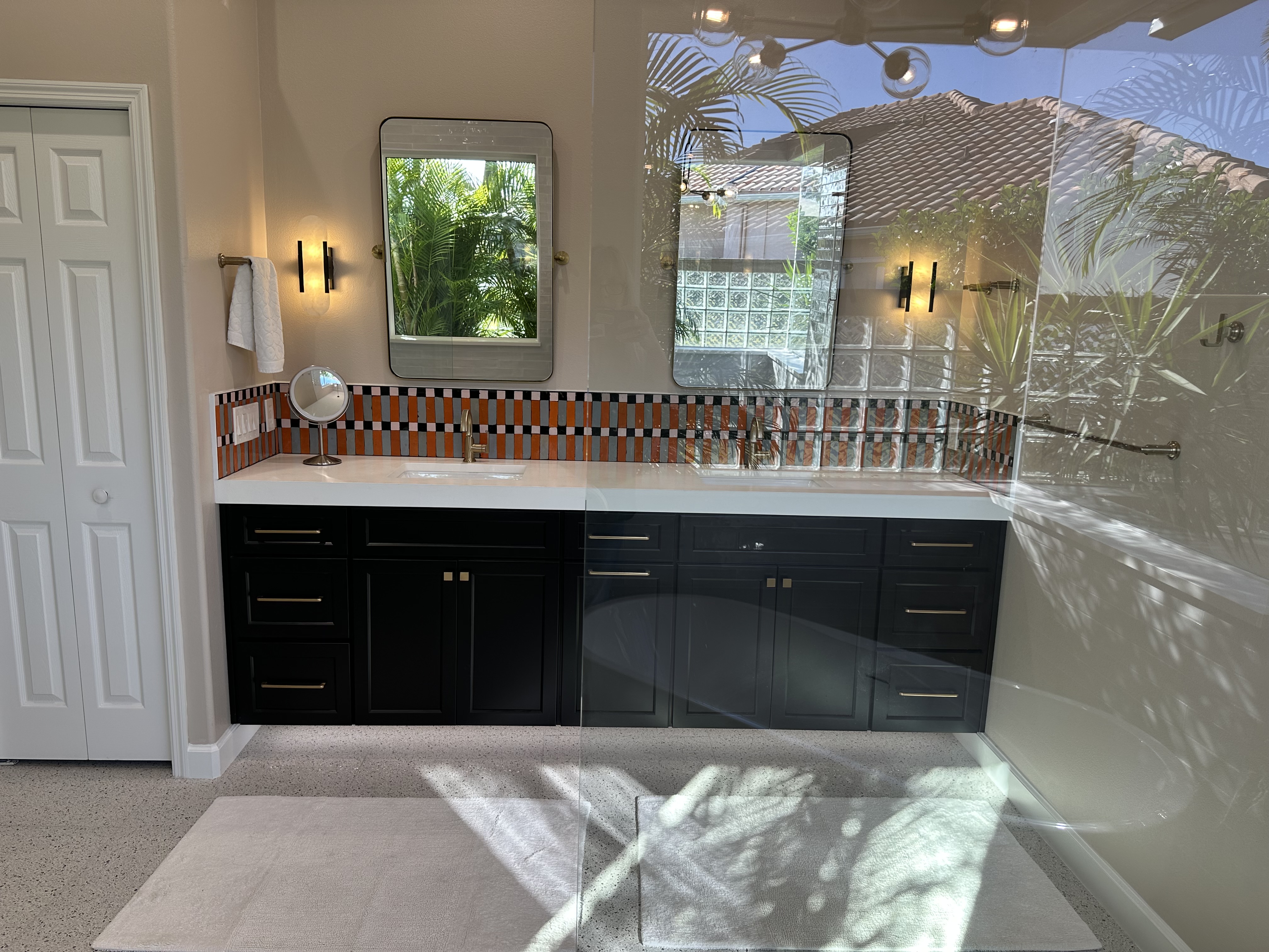 This standout bathroom features a large vanity with double sinks and dual mirrors for both style and functionality.