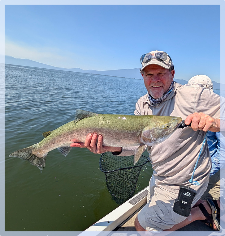 A man on the water, holding a long fish A man on the water, holding a long fish