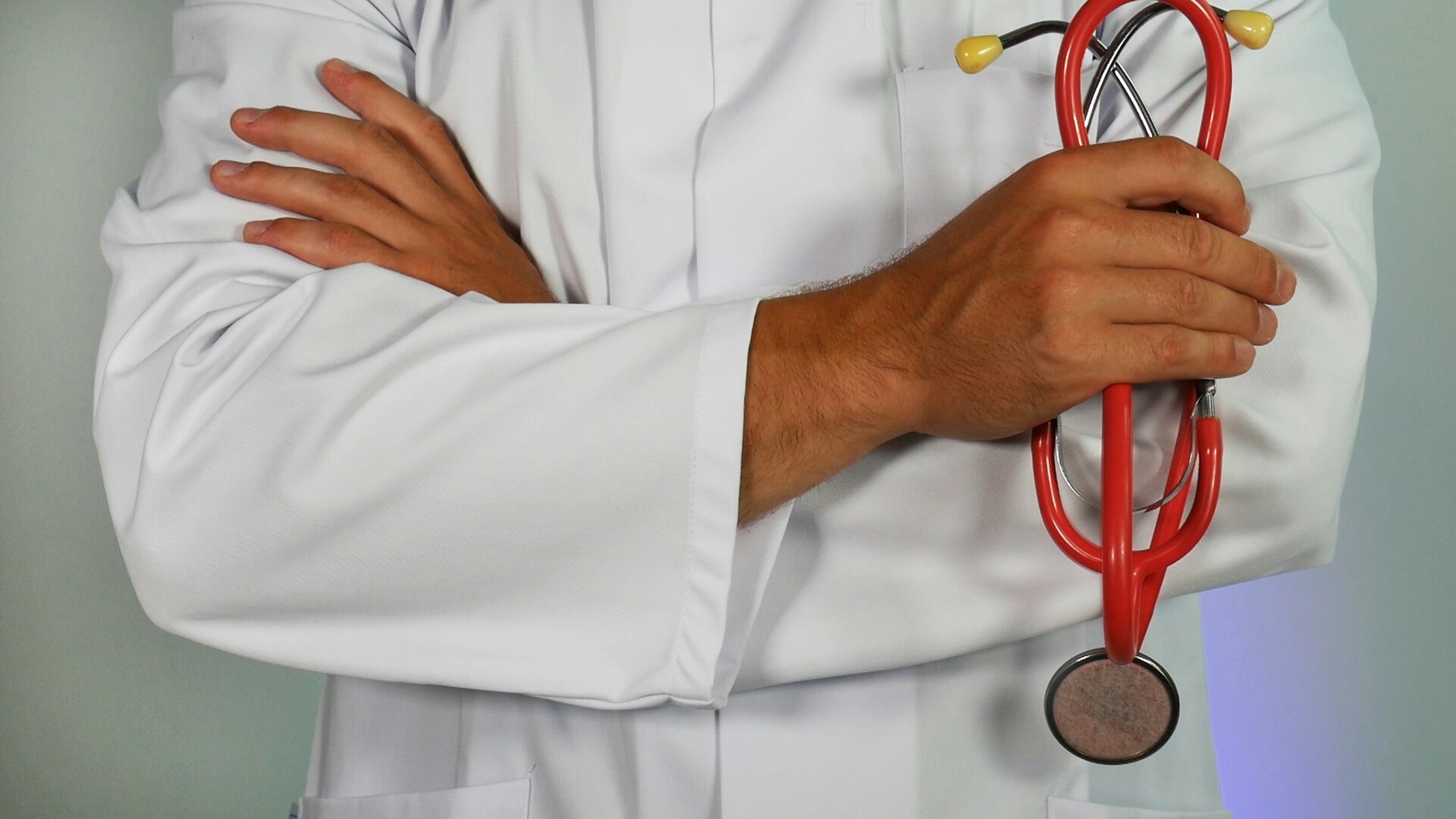 doctor sosteniendo un estetoscopio rojo