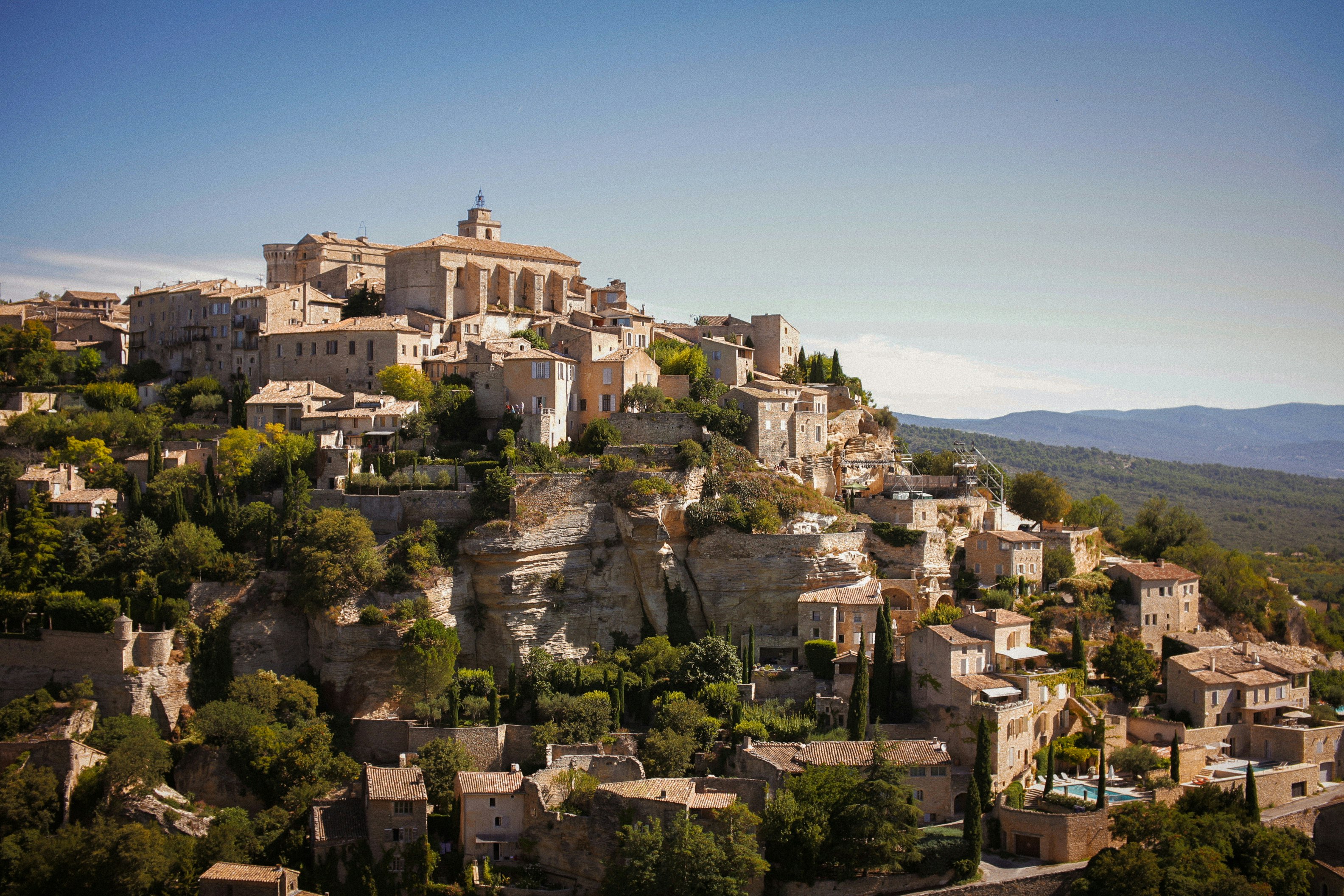 un pueblo en la cima de una colina rodeado de árboles un pueblo en la cima de una colina rodeado de árboles