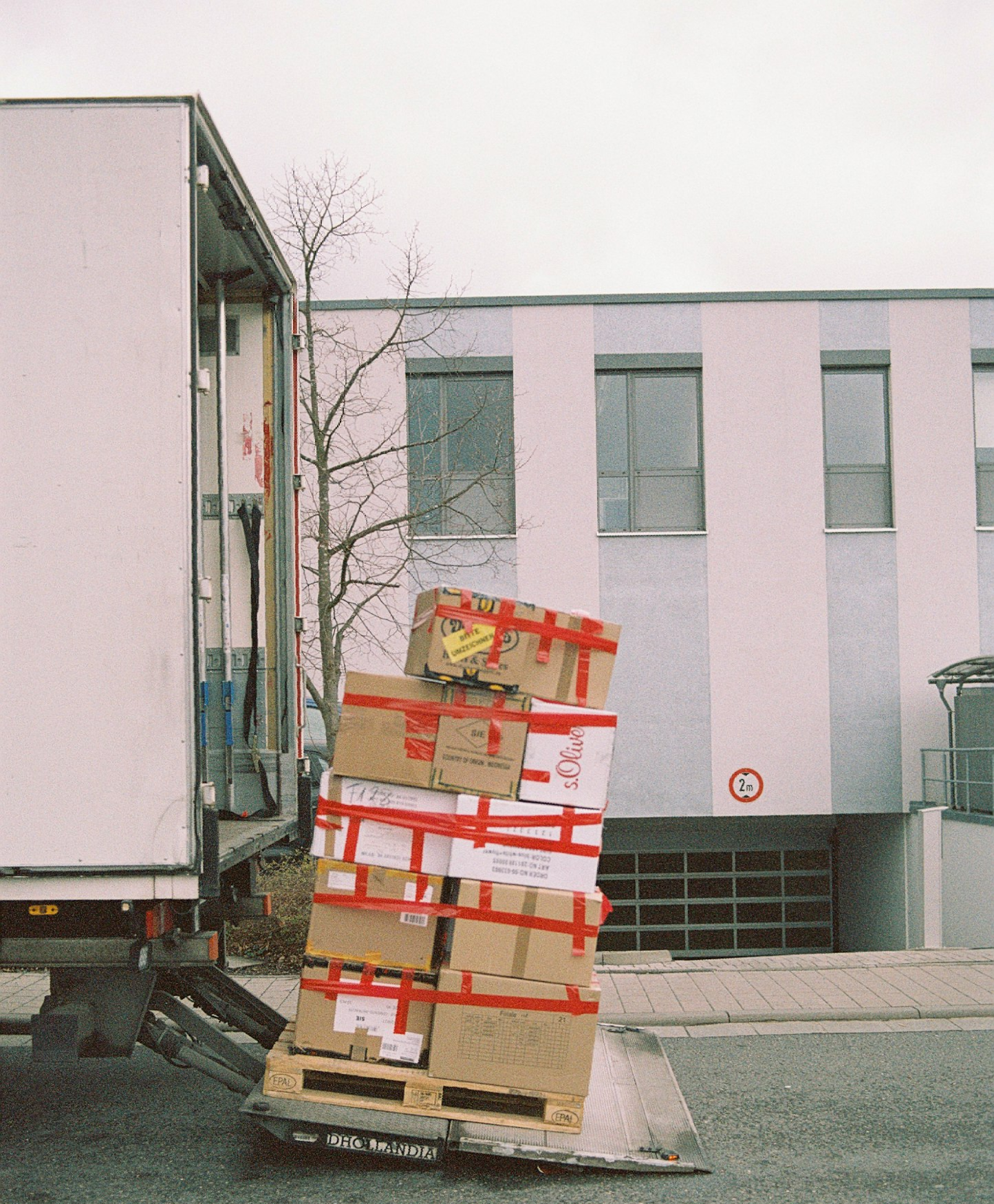 Camión blanco conduciendo por una carretera rodeada de árboles y montañas en un día soleado. Camión blanco conduciendo por una carretera rodeada de árboles y montañas en un día soleado.