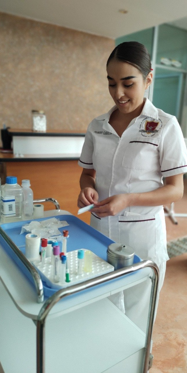 Enfermera preparando suministros médicos en una bandeja en un ambiente hospitalario.