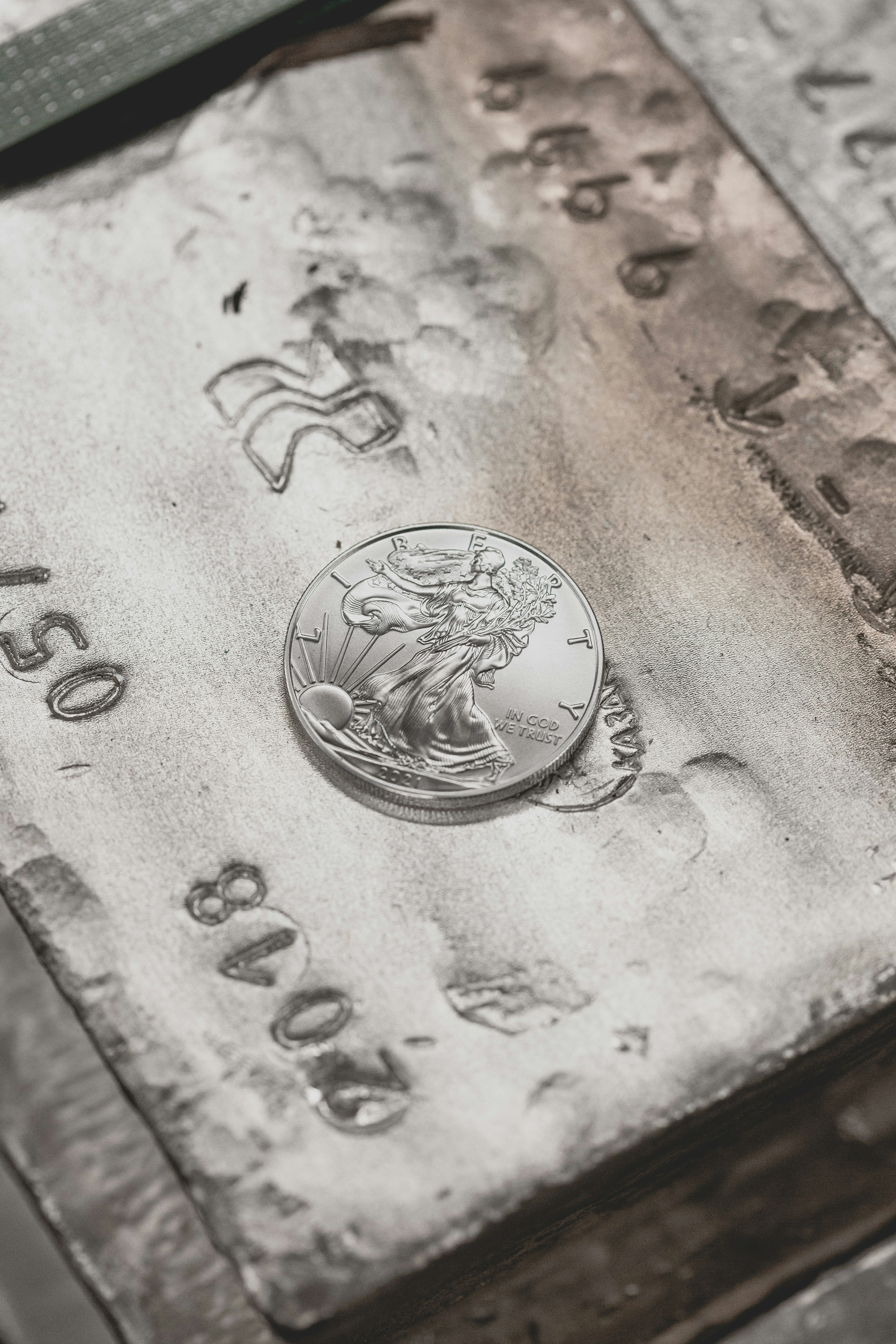 Collection of assorted vintage coins in various metals including gold and silver on a dark surface.