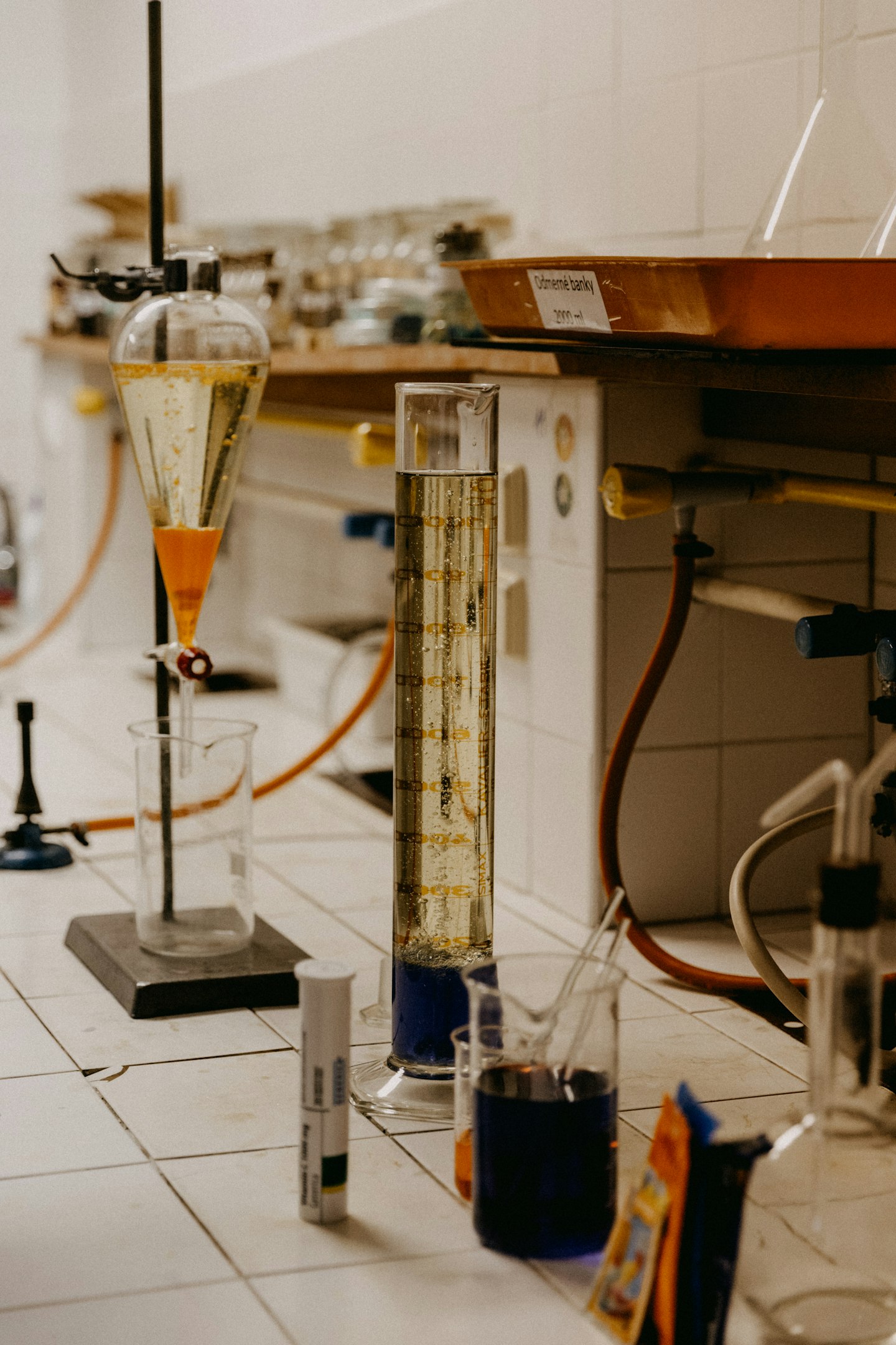 Laboratorio de investigación automotriz con coche deportivo naranja y escritorios con computadoras.